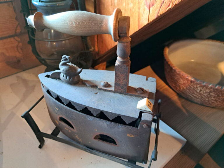 Altes Bolzen-Bügeleisen auf Holztisch