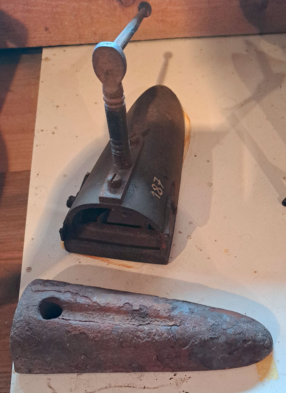 Altes Bolzen-Bügeleisen auf Holztisch