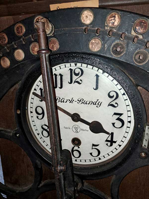 Zu sehen ist ein Ziffernblatt einer alten Stempeluhr/Stechuhr